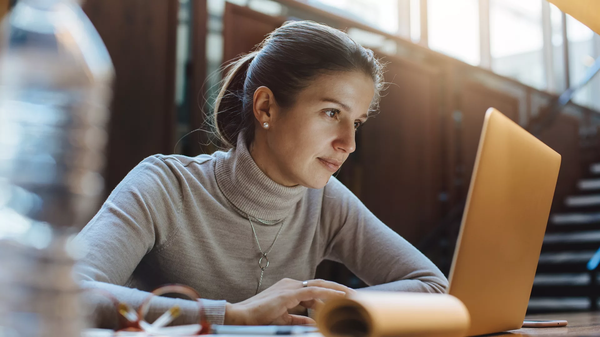 Business woman using laptop in open work space 