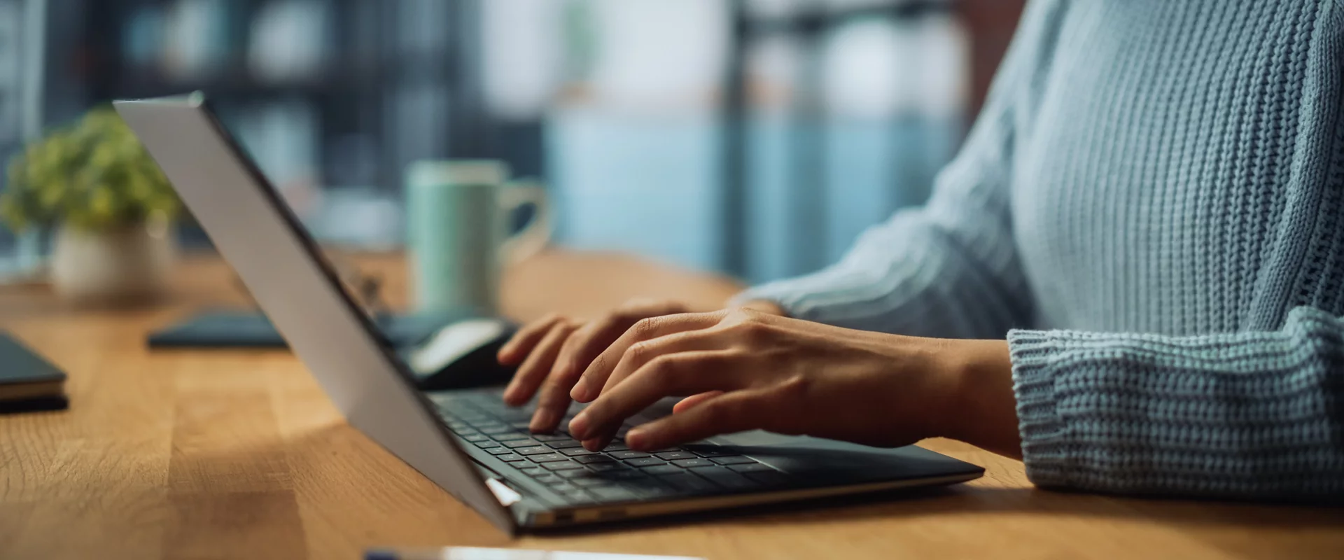 Close Up on Hands of a Female Specialist Working on Laptop Computer at Cozy Home Living Room while Sitting at a Table. Freelancer Woman Chatting Over the Internet on Social Networks.