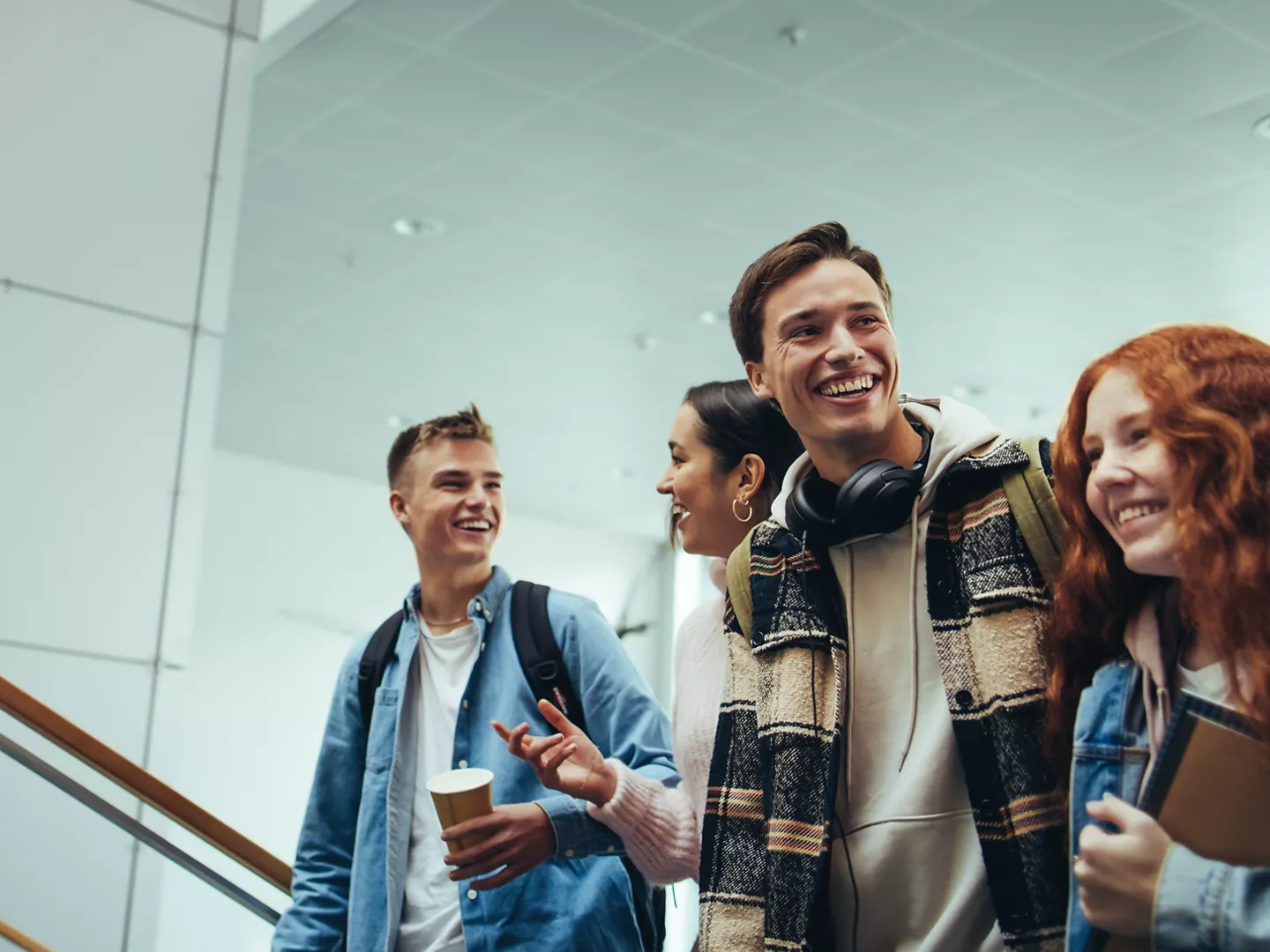 Group of young people walking and talking in university. College students going for their class.